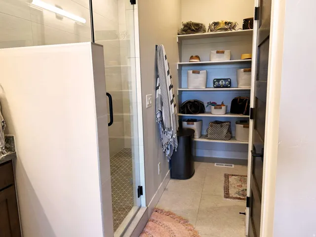 Walk-in shower with clear glass enclosure and black hardware
