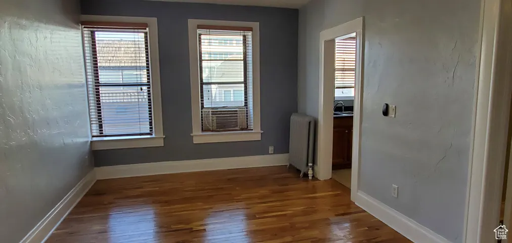 # 9 Unfurnished room with large 5' window, Ktch entry and dark wood finished floors
