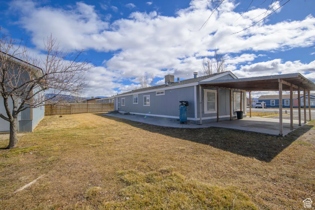 Exterior space with a patio area, a fenced backyard, a yard, and an attached carport