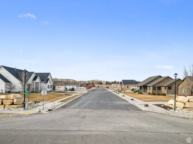 View of road with street lights, traffic signs, sidewalks, a residential view, and curbs