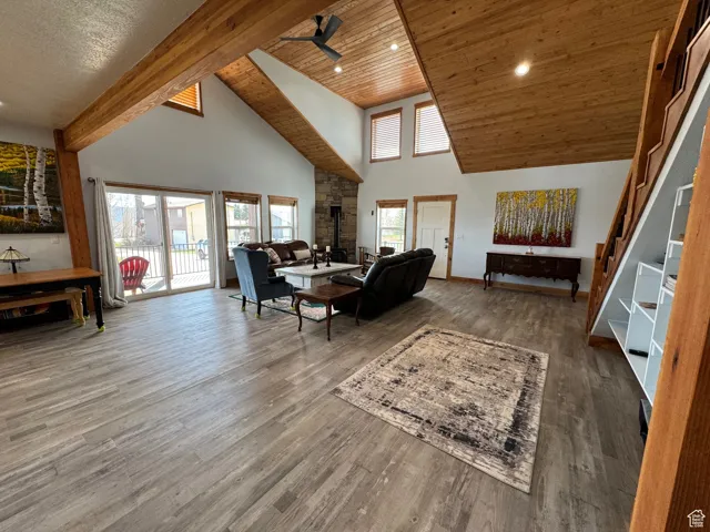 Living area featuring ceiling fan, high vaulted ceiling, wooden ceiling, and wood finished floors