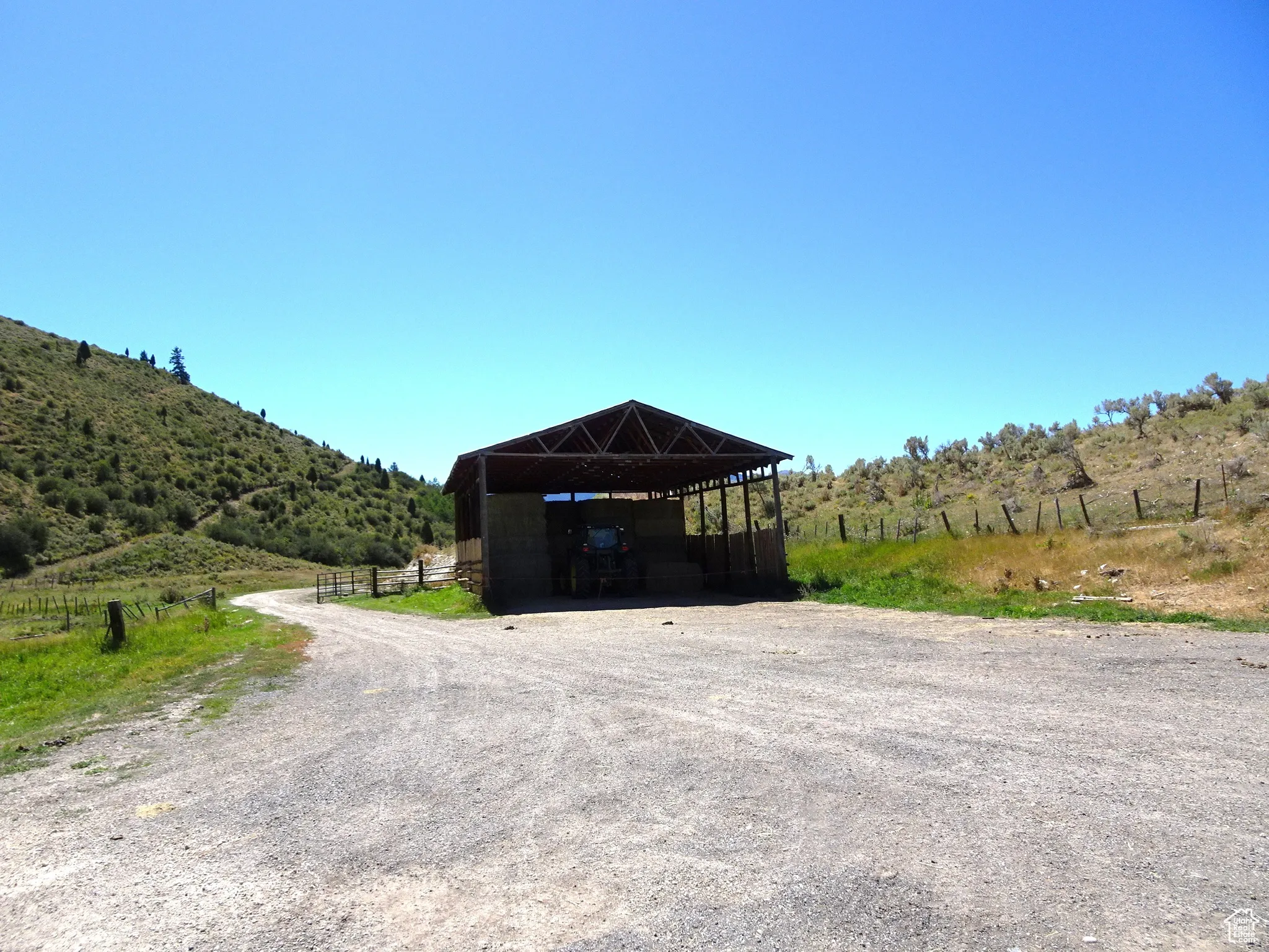 View of outbuilding featuring a view of countryside, gravel driveway, and a detached carport