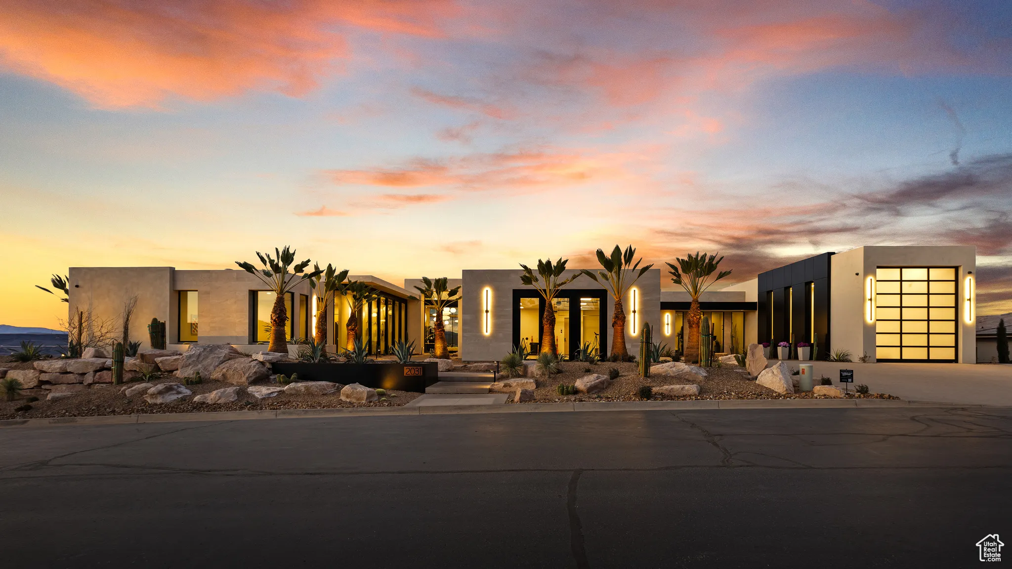 View of front facade featuring driveway, a garage, and stucco siding