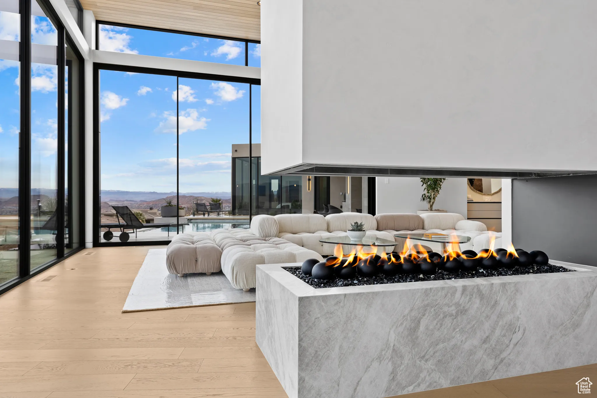 Living area with expansive windows, light wood finished floors, and a mountain view