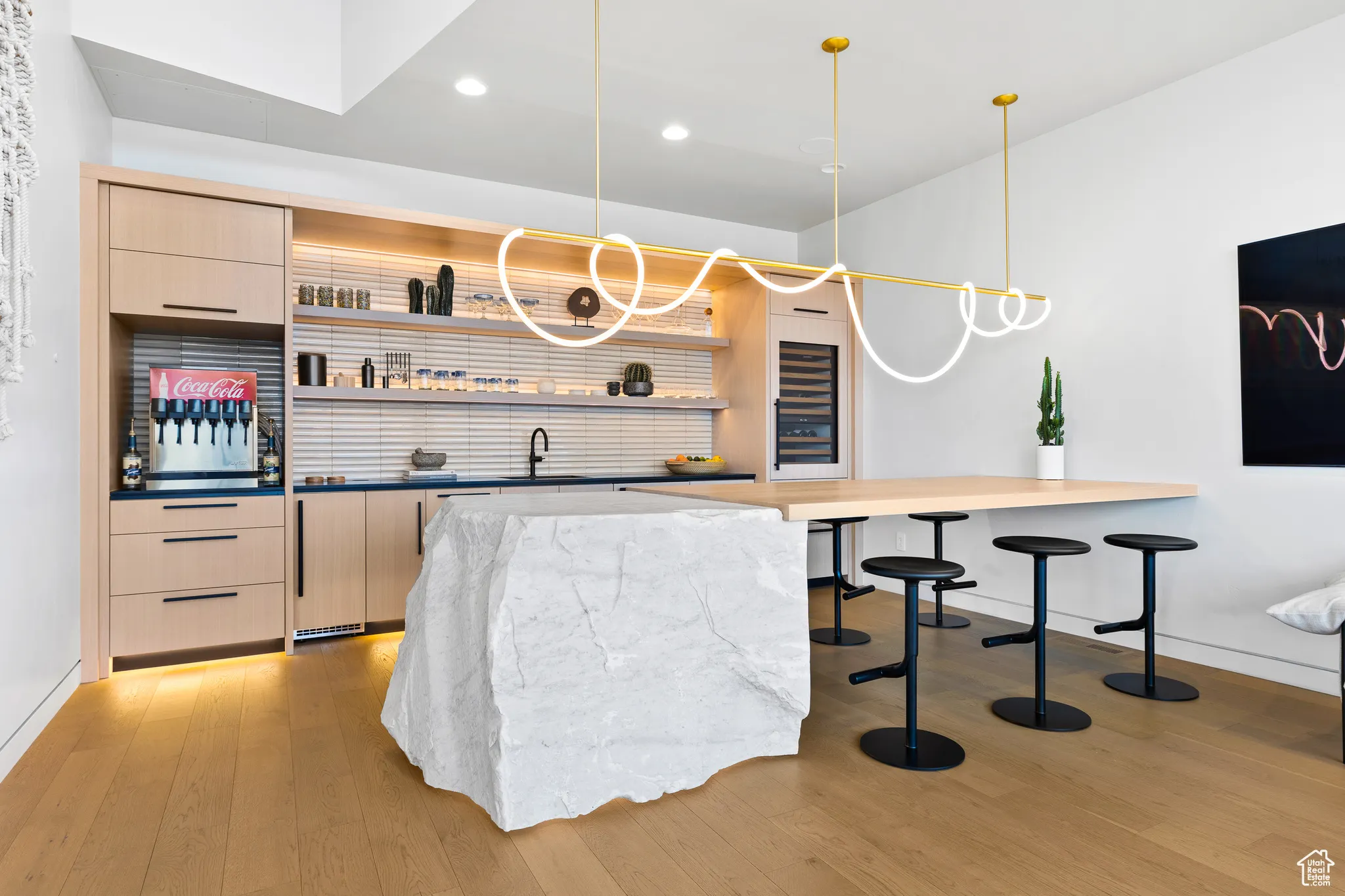 Bar featuring pendant lighting, recessed lighting, light wood-style floors, a sink, and baseboards