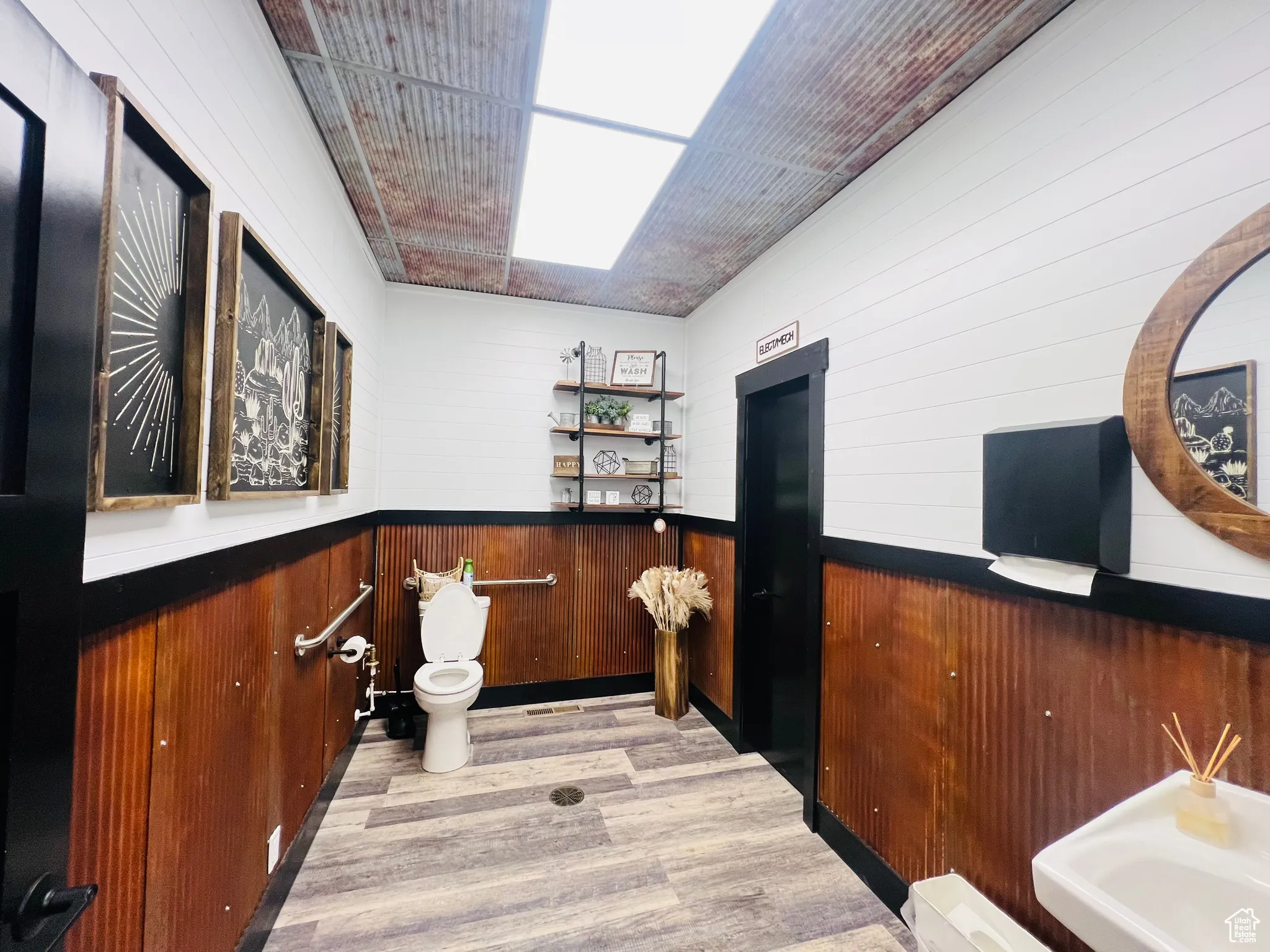 Bar featuring wainscoting, light wood-type flooring, and wooden walls
