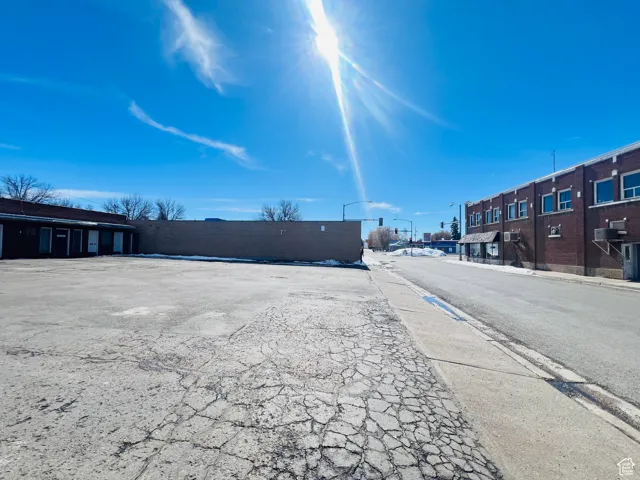 View of road featuring curbs, sidewalks, and street lights