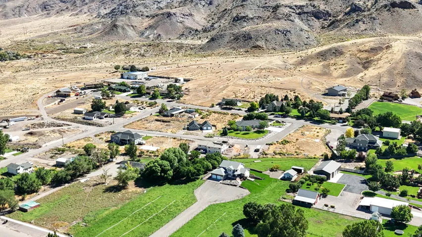 Aerial view of property's location with a mountainous background and nearby suburban area