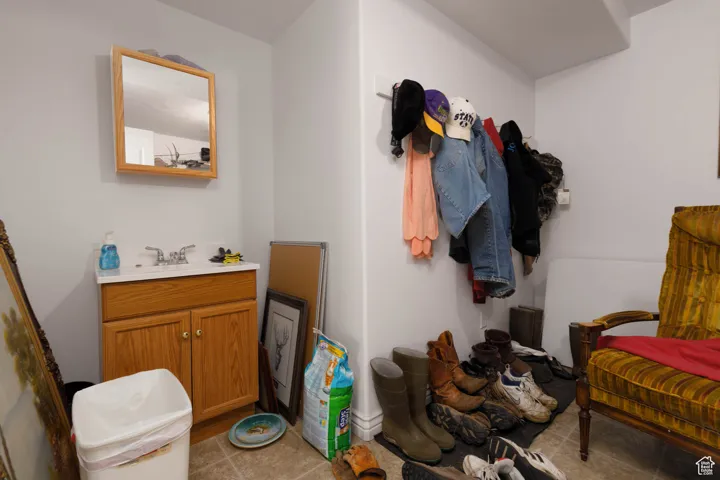 Mudroom with light tile patterned floors and a sink