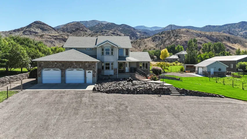 View of front facade with a mountain view, driveway, covered porch, and an attached garage