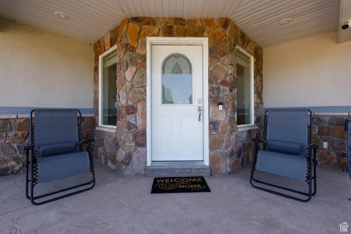 Entrance to property featuring stone siding