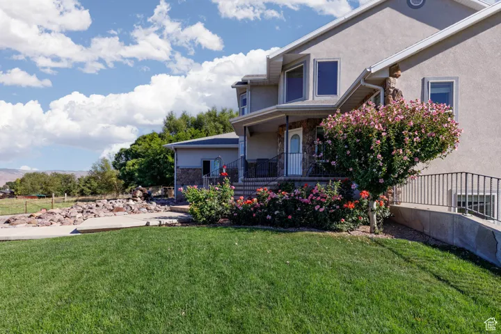 View of grassy yard with covered porch
