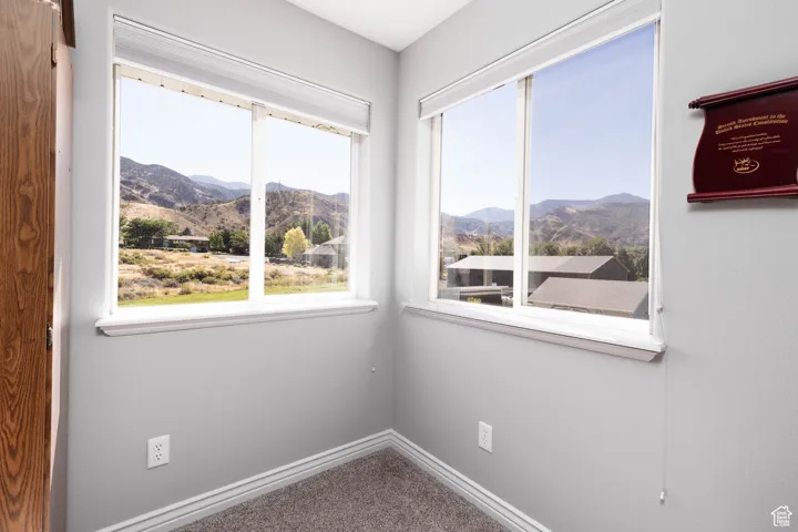 Carpeted spare room with a mountain view and plenty of natural light