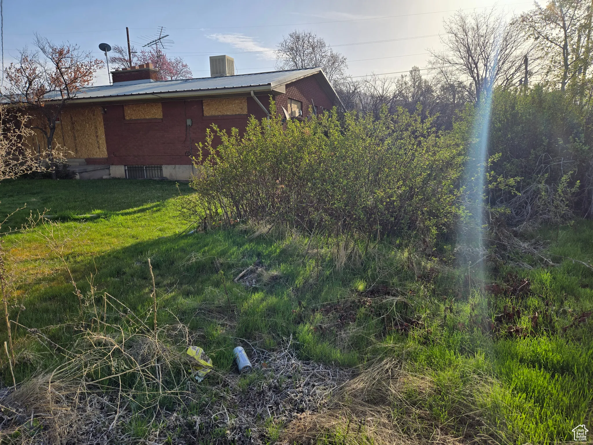 View of property exterior with a yard, metal roof, cooling unit, and a chimney