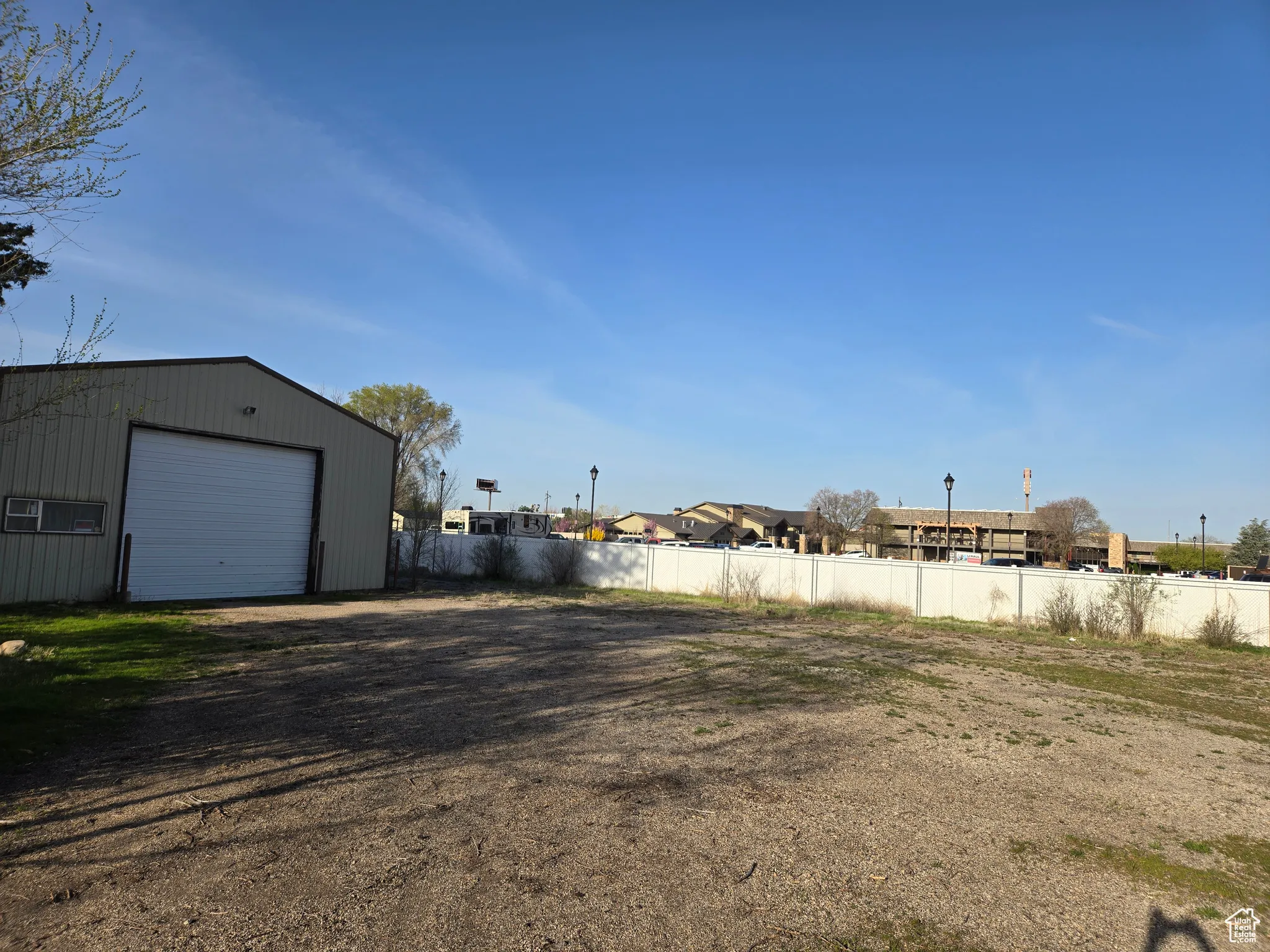 View of yard with a detached garage, fence, and an outdoor structure