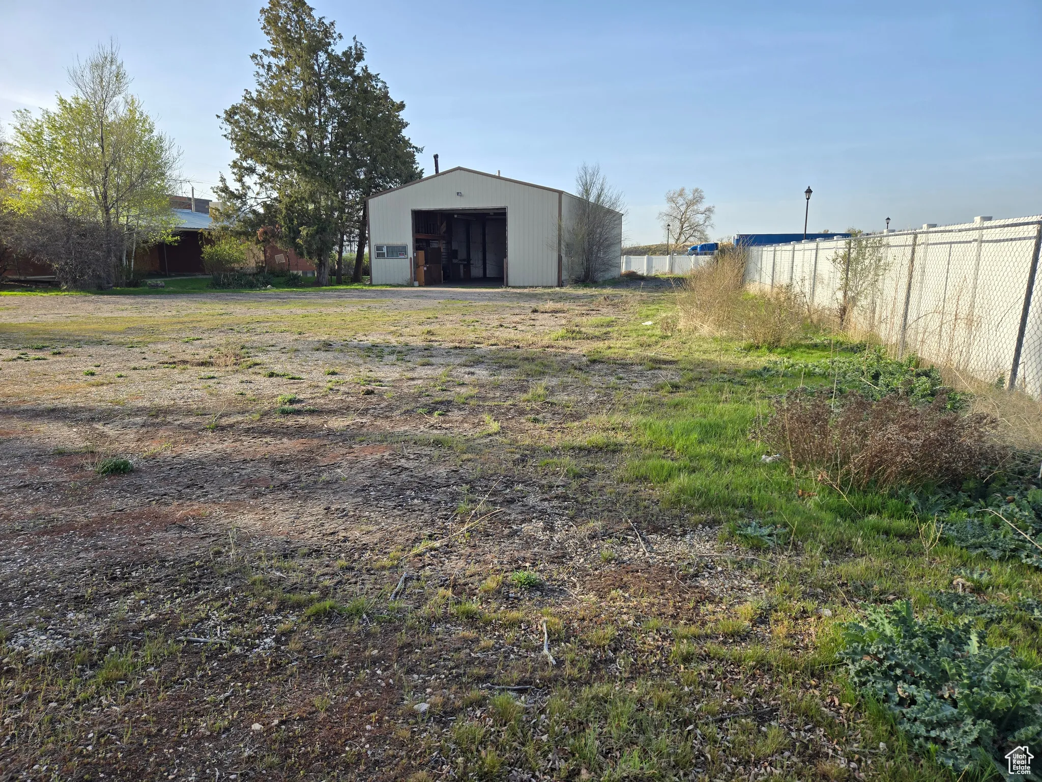 View of yard featuring fence and an outbuilding