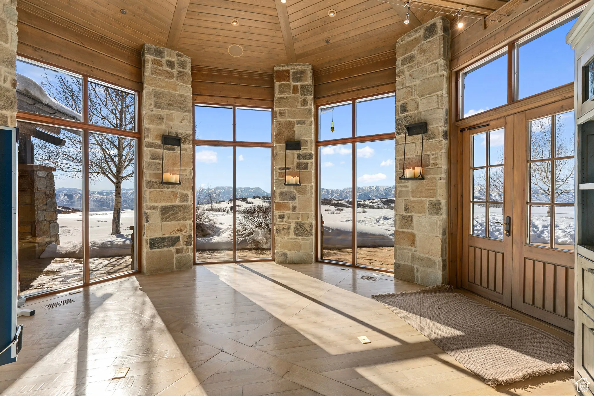 Fitness area with doorway to outside and jacuzzi, featuring wood ceiling, high vaulted ceiling, french doors, and a mountain view