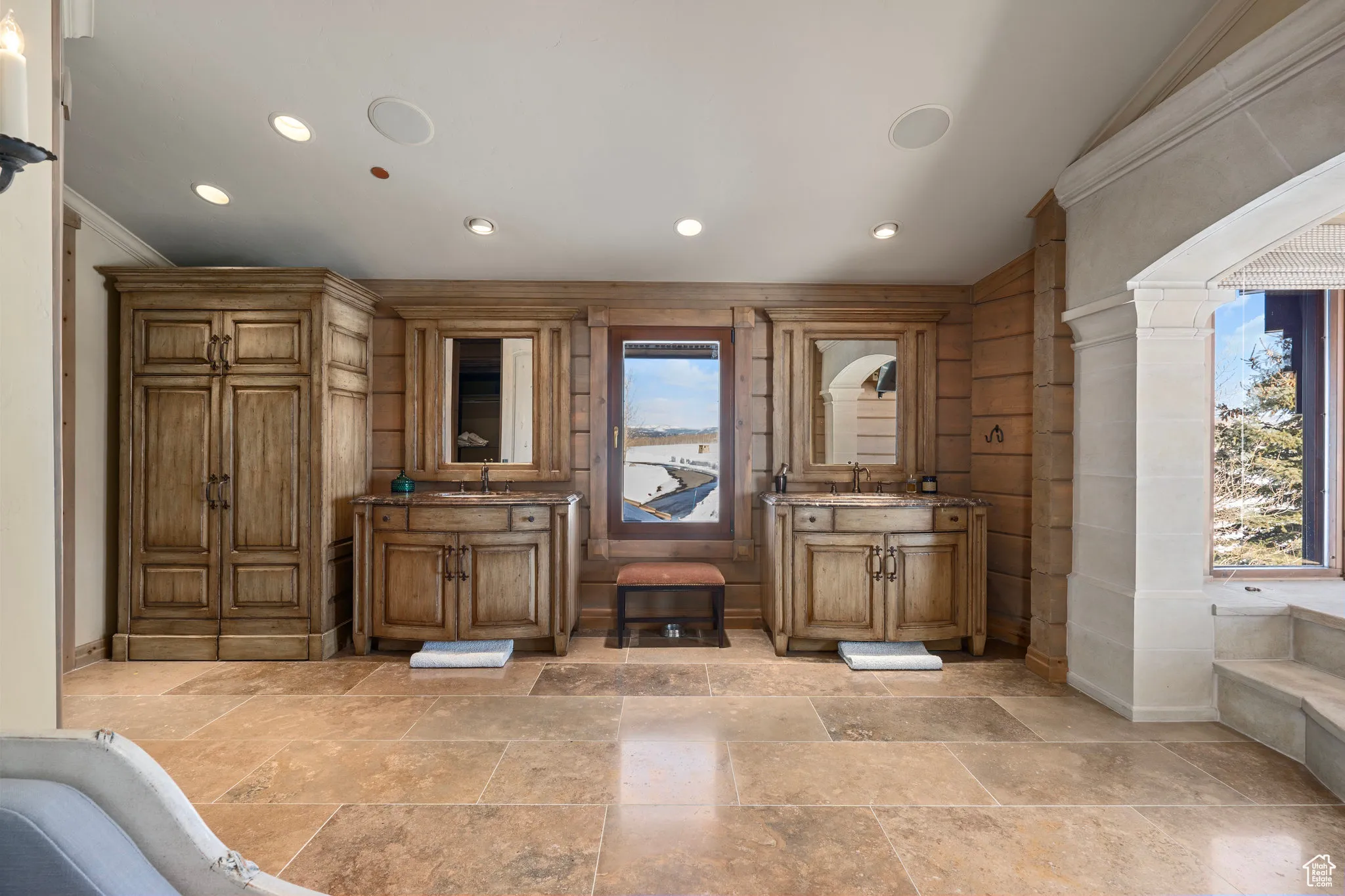 Interior space with ornamental molding, two vanities, a sink, and recessed lighting