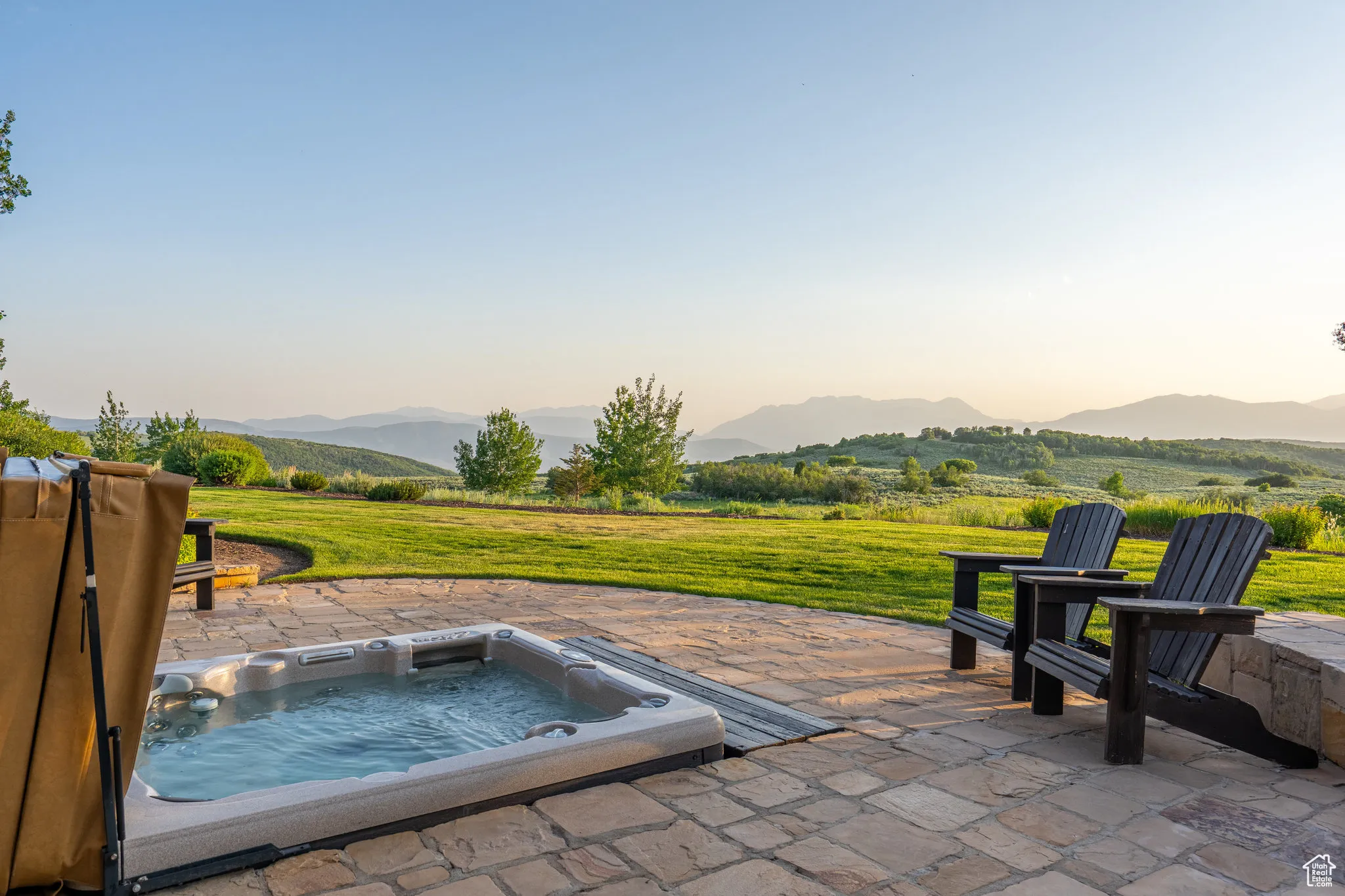 View of patio / terrace with an outdoor hot tub and a mountain view