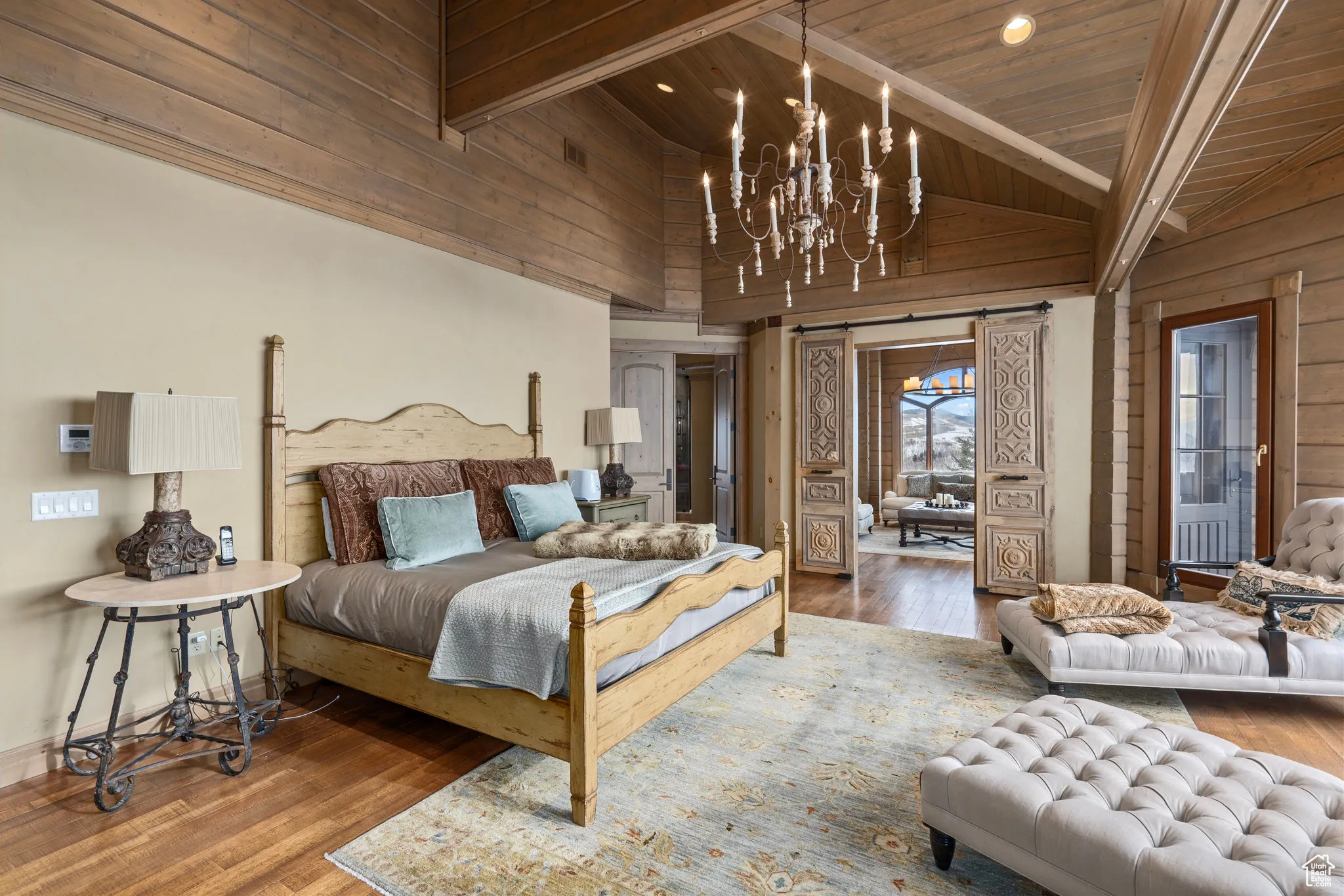 Bedroom featuring an inviting chandelier, wood finished floors, and beamed ceiling