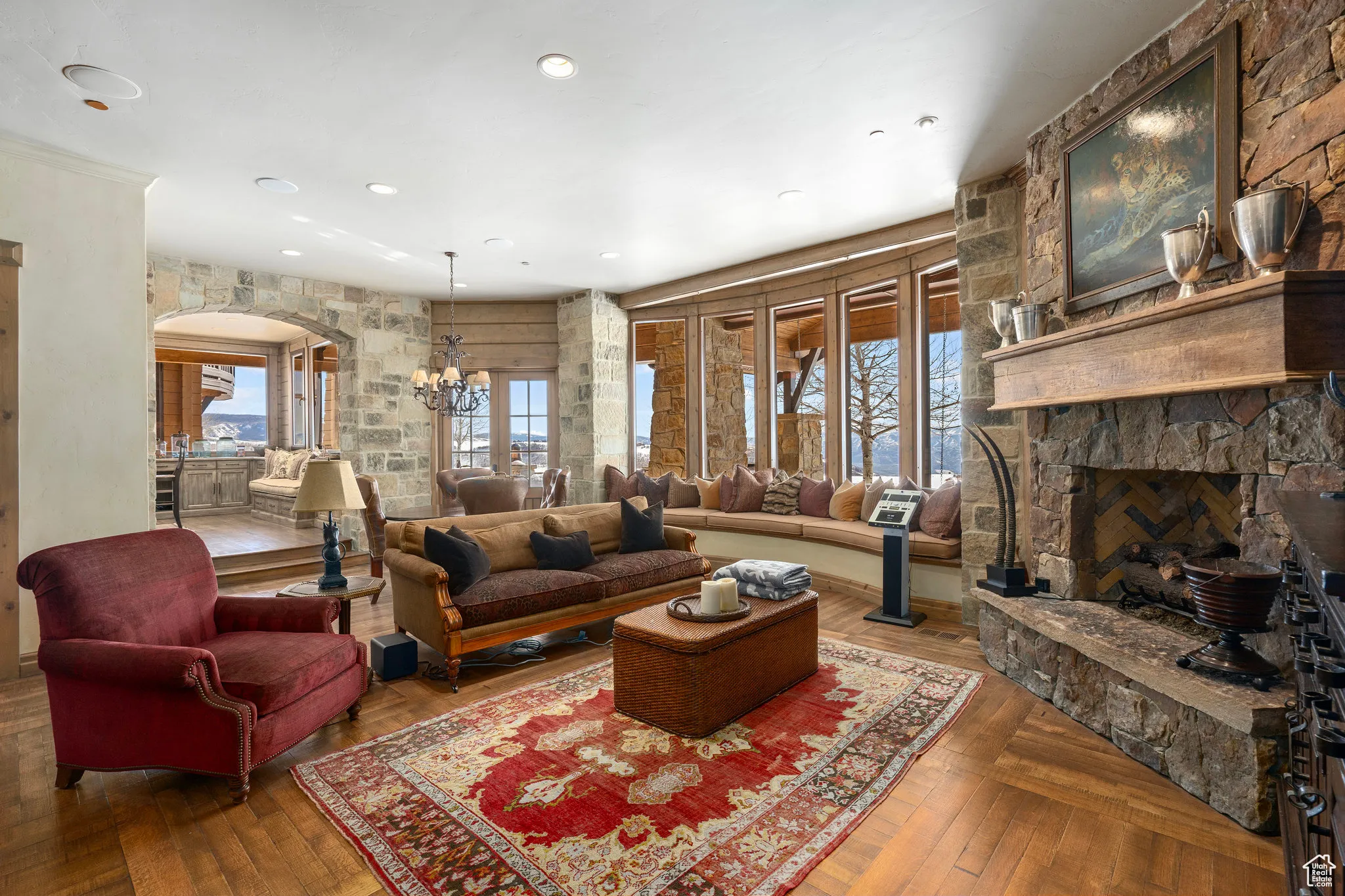 Living area featuring arched walkways, a notable chandelier, a fireplace, and hardwood / wood-style flooring