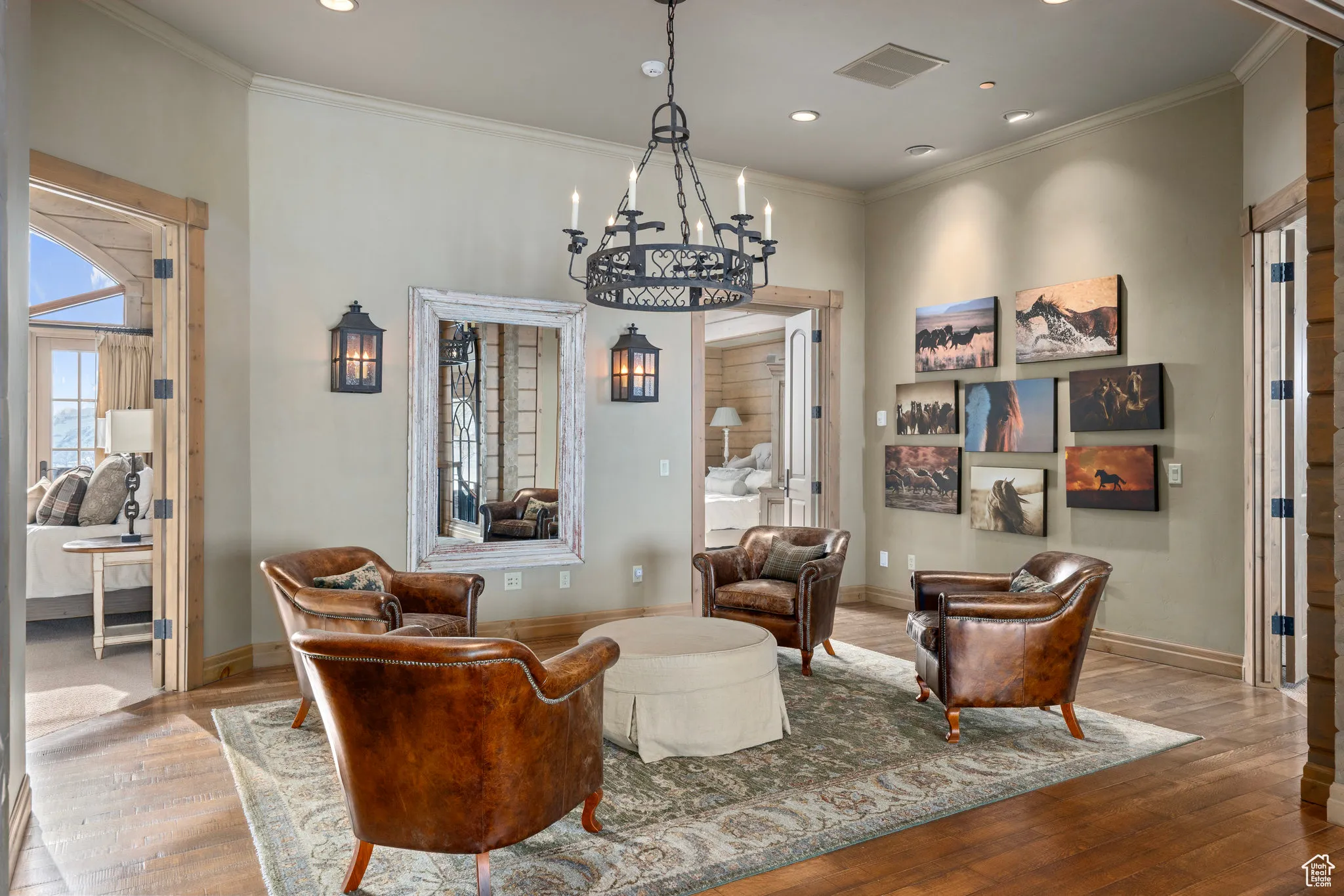 Sitting room with baseboards, visible vents, hardwood / wood-style floors, and ornamental molding