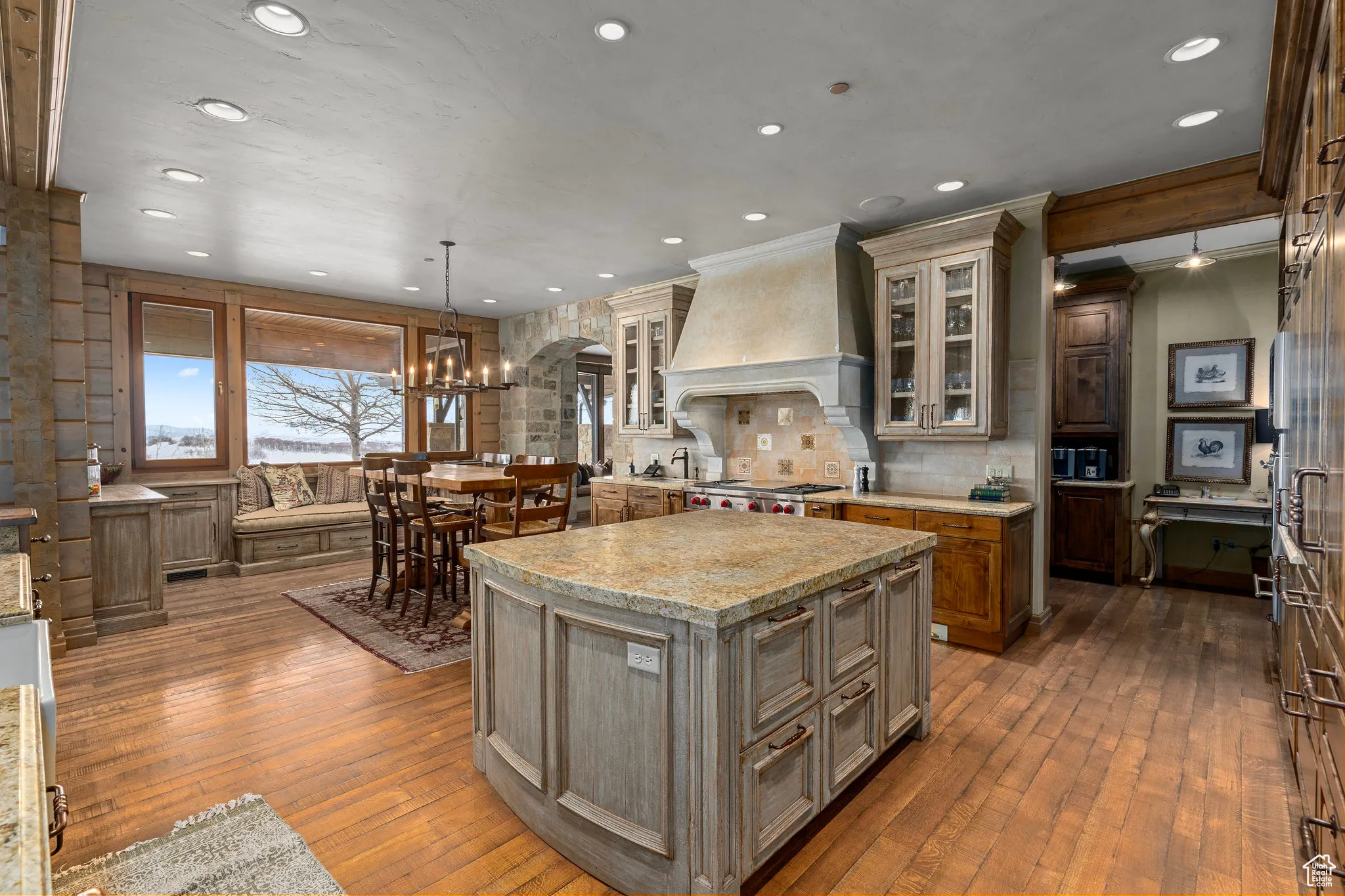 Kitchen with arched walkways, a center island, wood-type flooring, custom range hood, and decorative backsplash