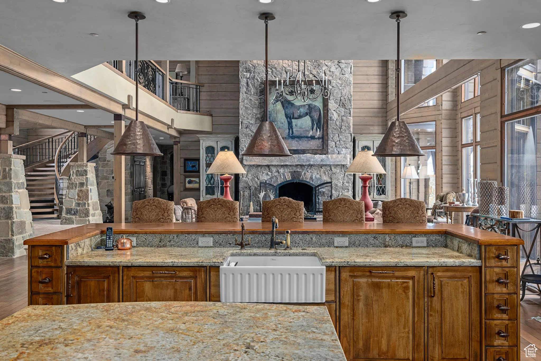 Kitchen with brown cabinets, a sink, and light stone countertops