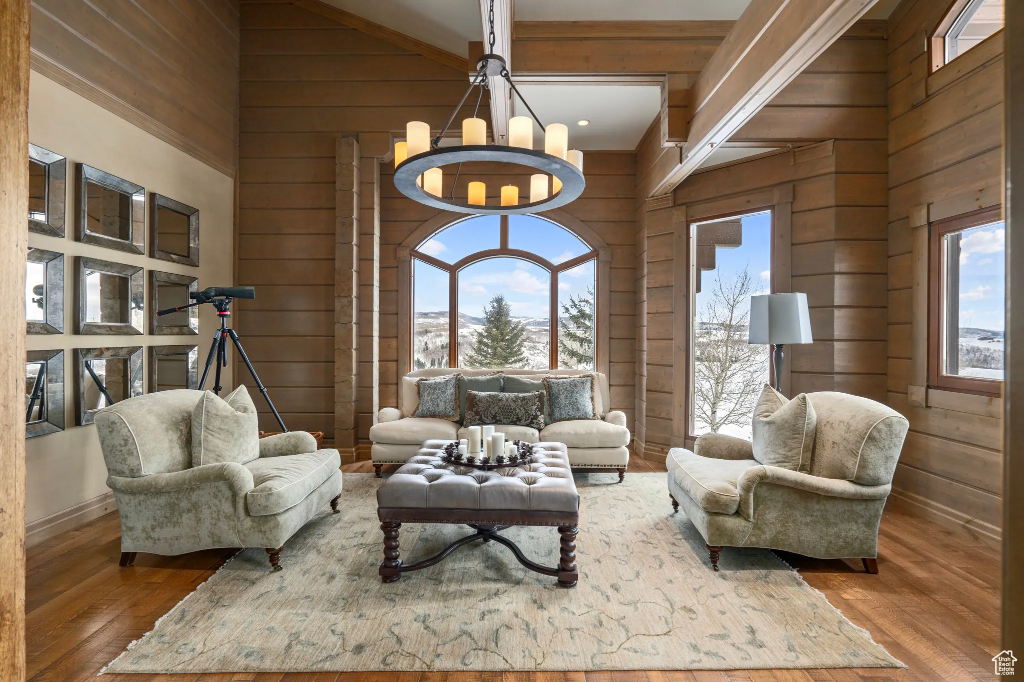Living area with a notable chandelier, a high ceiling, hardwood / wood-style flooring, and wooden walls