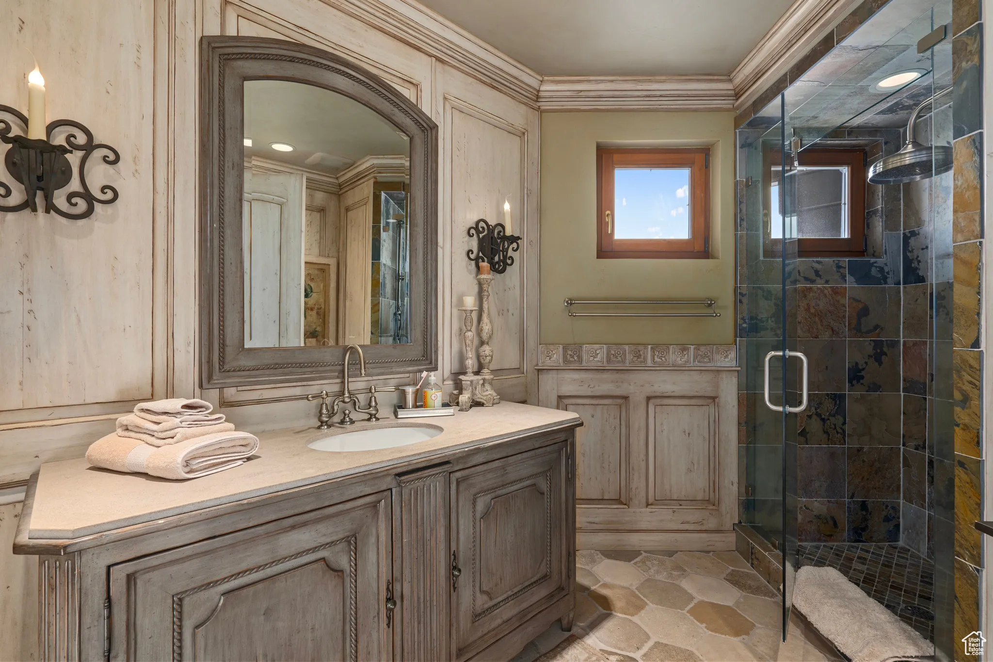 Bathroom featuring a stall shower, crown molding, and vanity