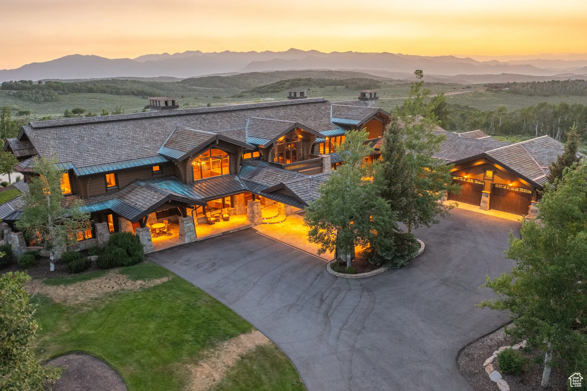View of front facade featuring curved driveway, a standing seam roof, a mountain view, and a garage