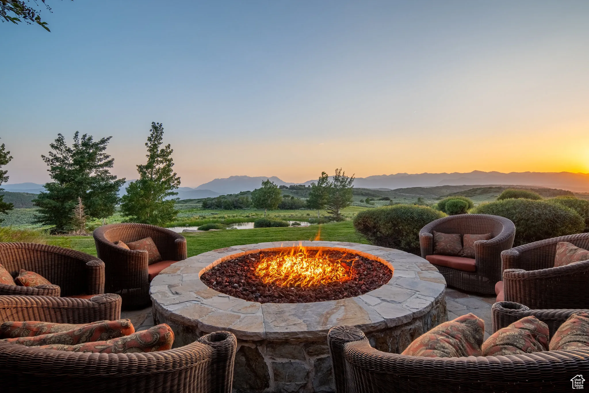 Patio terrace at dusk featuring an outdoor fire pit and a mountain view