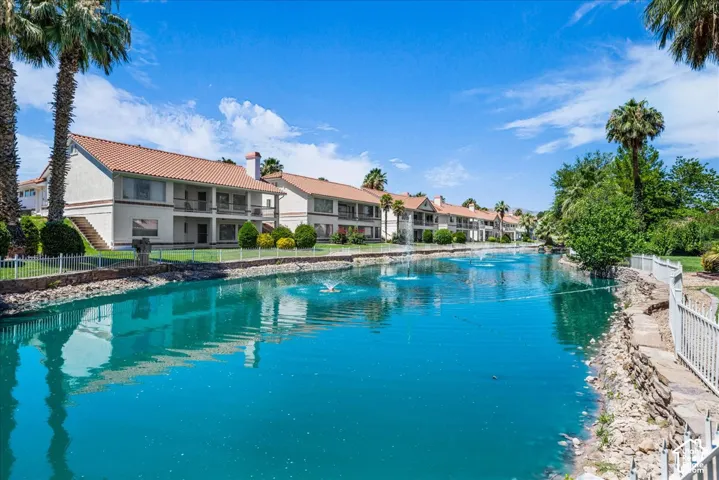 Waterfront properties featuring white stucco exteriors and red tile roofs