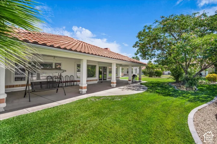 Expansive covered patio featuring multiple architectural columns, a tiled roof, and a concrete surface