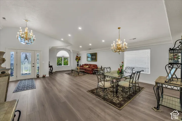 Expansive living area featuring vaulted ceilings, wood-finish flooring, recessed lighting, and crown molding
