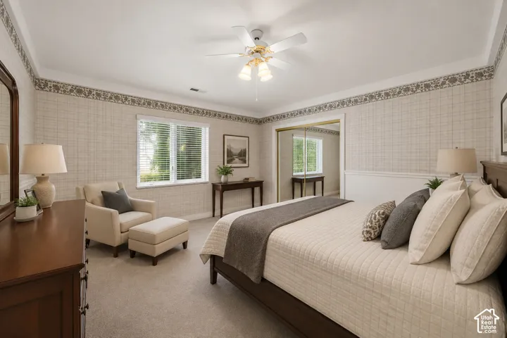Carpeted room featuring a ceiling fan with integrated lighting, a window with blinds, and white wainscoting