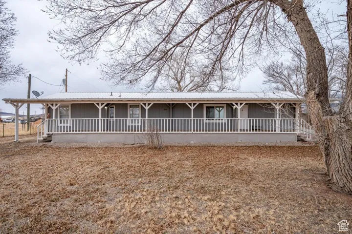Ranch-style house with covered porch and metal roof