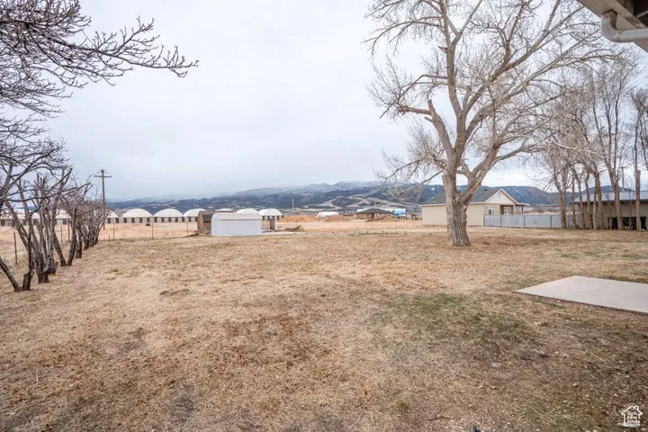 View of yard with fence and an outbuilding