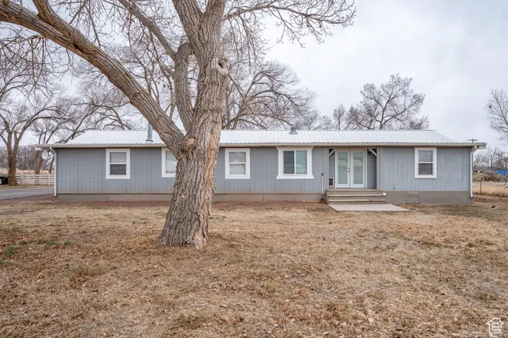 Ranch-style home featuring entry steps, french doors, and metal roof