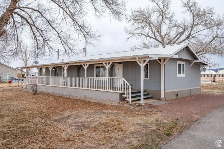 View of front of home with metal roof and a porch
