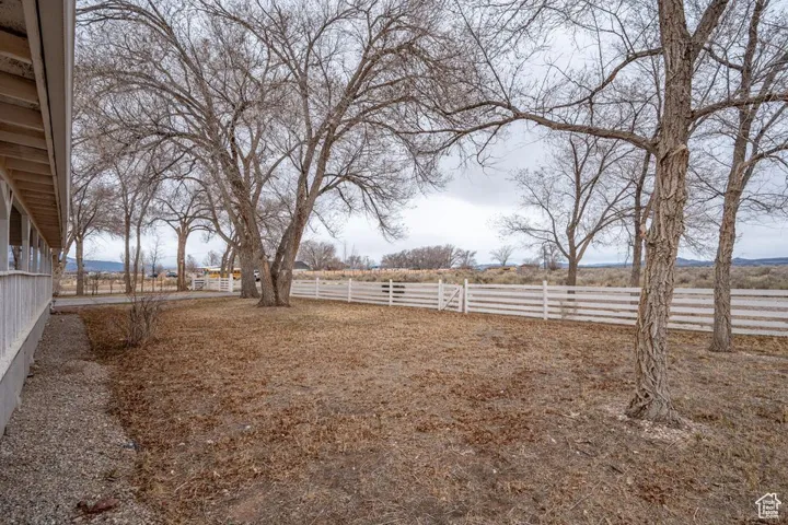 View of yard with a rural view and fence
