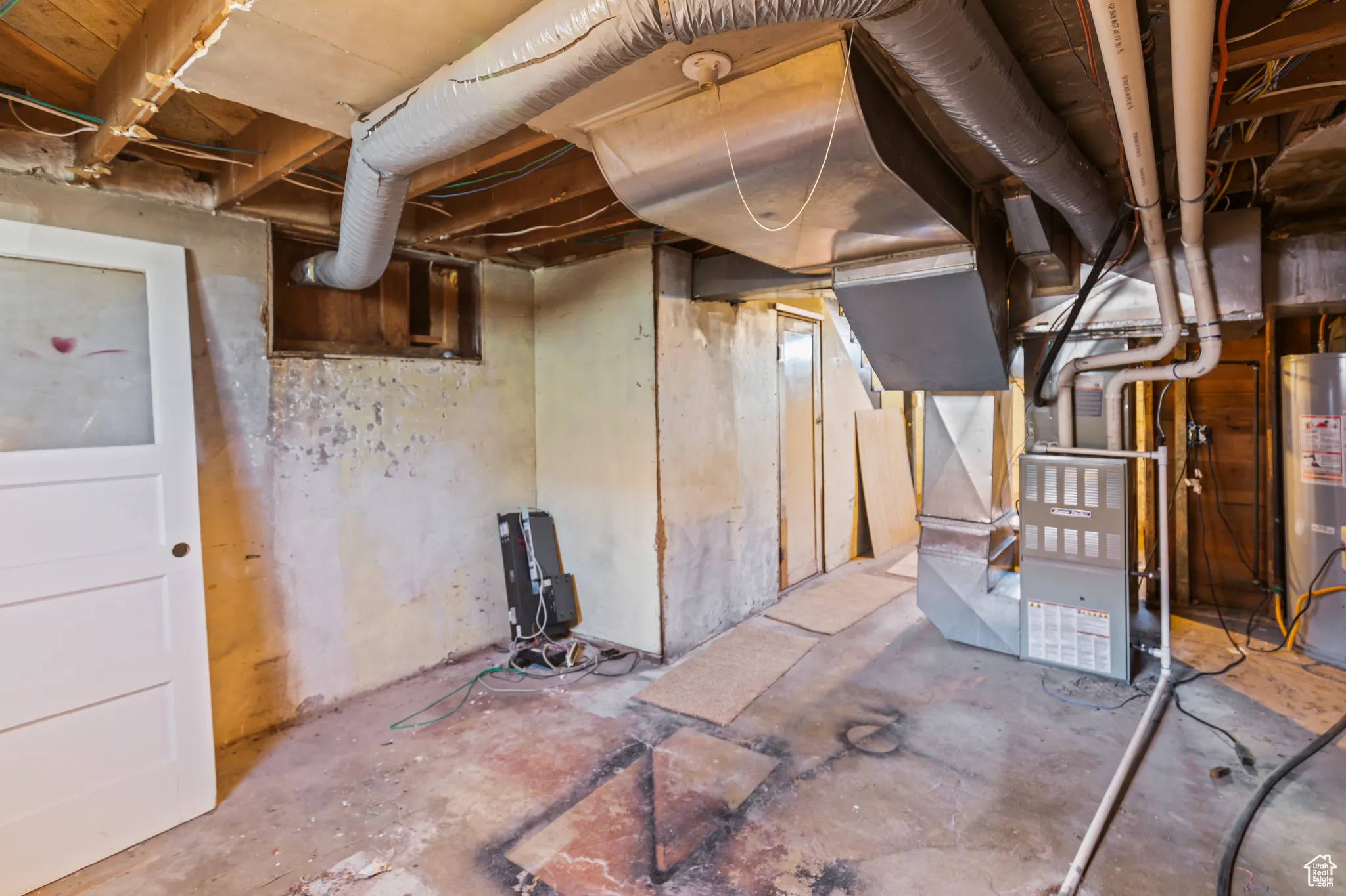 Unfinished below grade area with heating unit and water heater