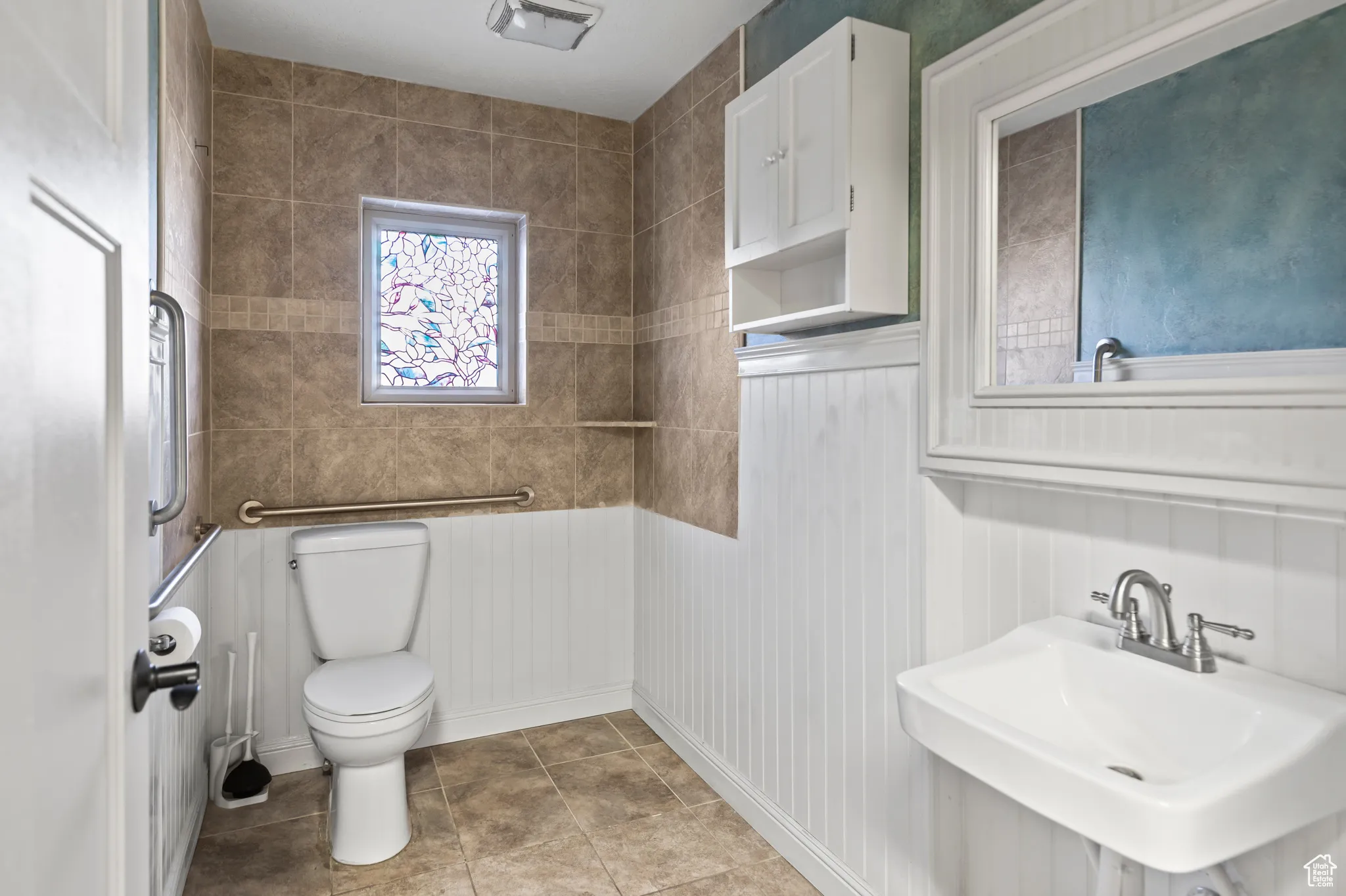 Bathroom featuring tile patterned flooring, visible vents, toilet, and a sink