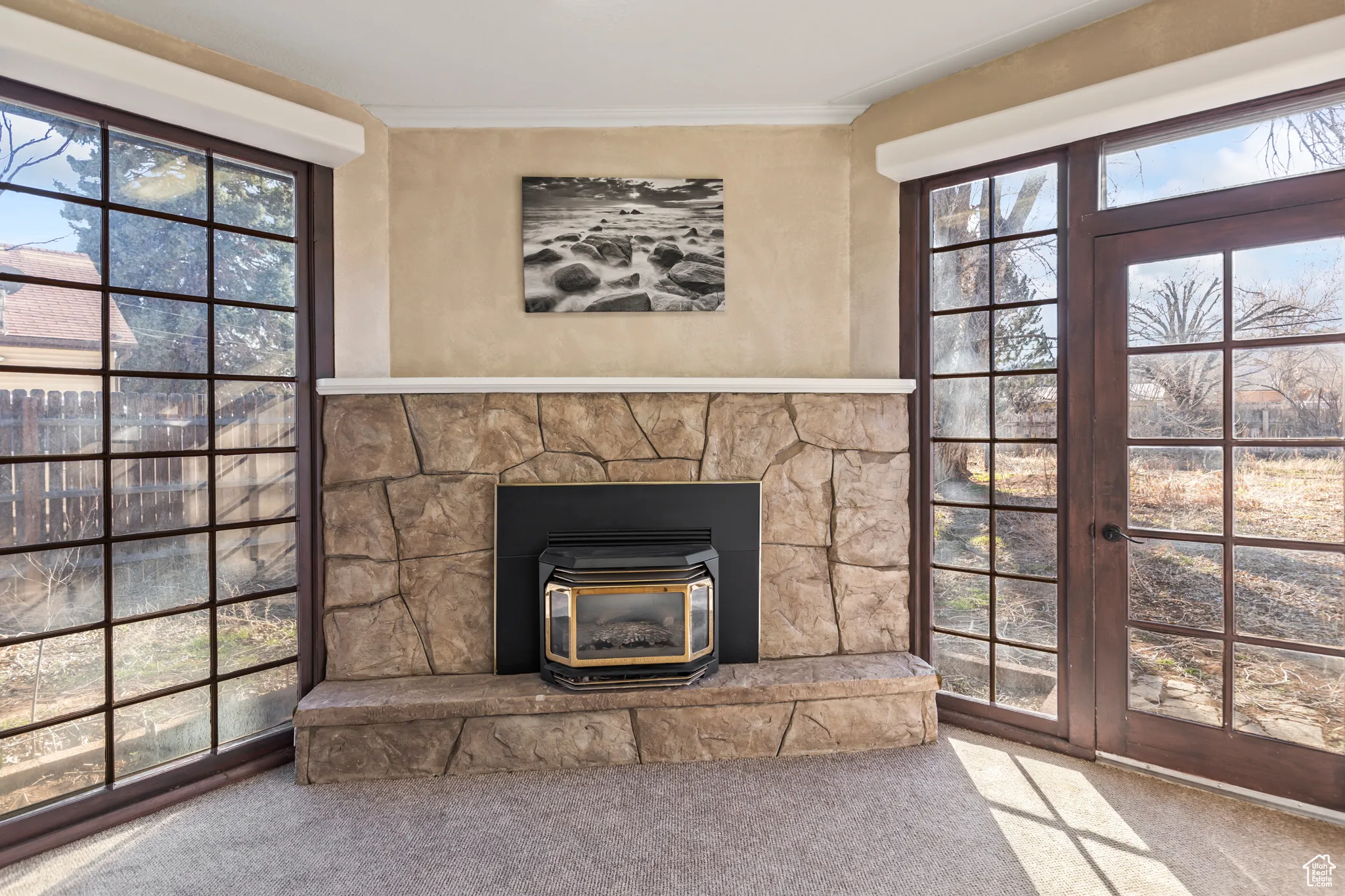Room details with a wood stove, carpet, and ornamental molding