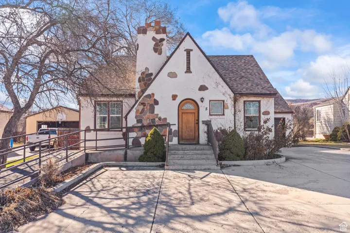 Tudor house featuring stucco siding and roof with shingles