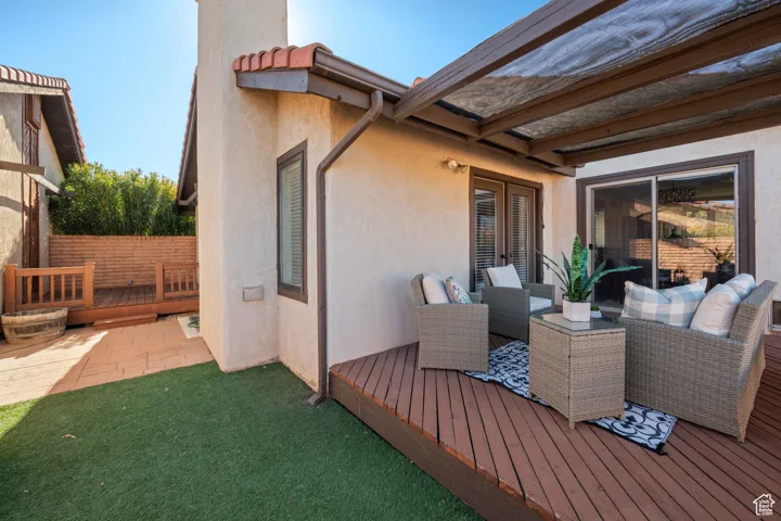 Deck featuring french doors, an outdoor hangout area, and fence