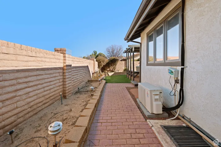 View of property exterior featuring stucco siding, a fenced backyard, and ac unit