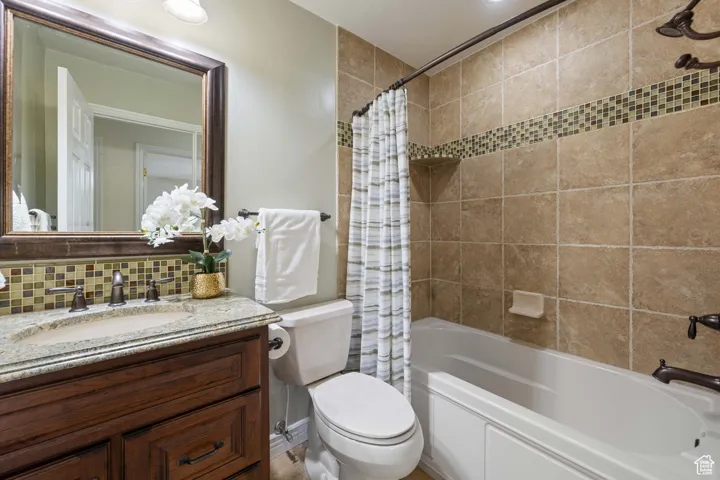 Bathroom featuring decorative backsplash and shower / bath combo with shower curtain