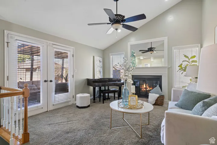 Living room featuring a  fireplace, french doors, and a vaulted ceiling
