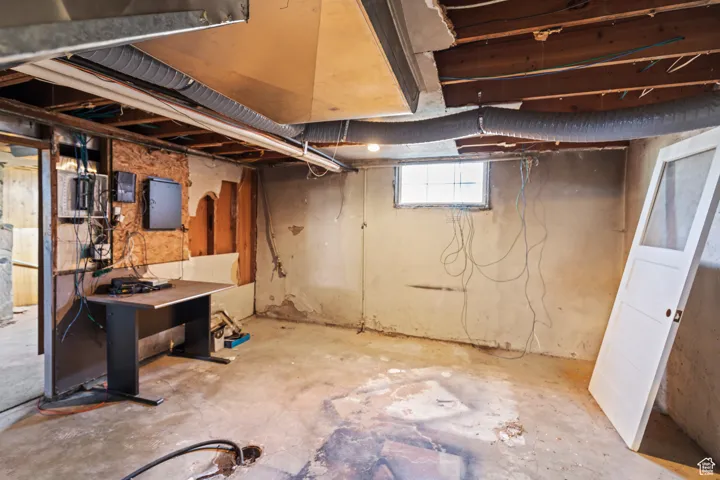 Basement featuring electric panel and water heater
